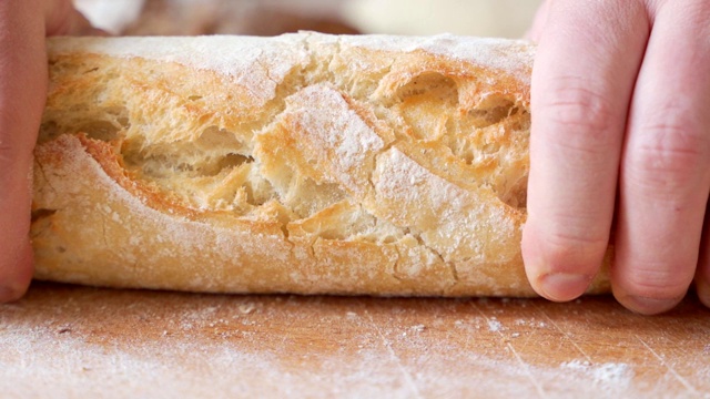 用手掰开刚烤好的面包的慢动作视频素材