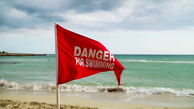 在海滩上游泳有危险，请出示红旗。视频素材