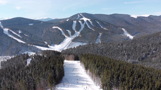 鸟瞰图在滑雪缆车附近的山顶滑雪坡上滑雪的人群。滑雪胜地视频下载