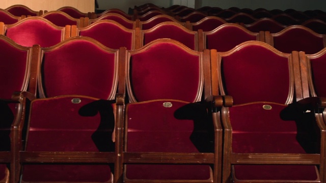 空无一人的剧院大厅里，一排排被聚光灯照亮的红色天鹅绒椅子视频素材