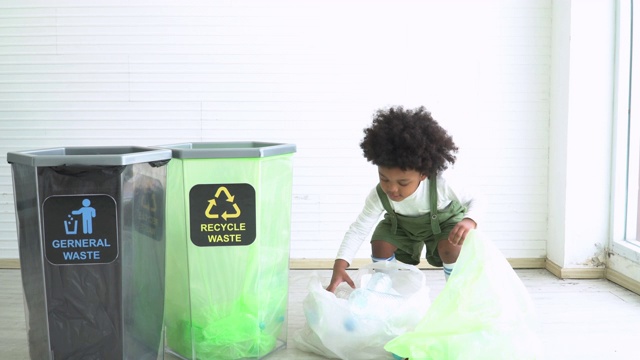 两个不同种族的孩子帮助把塑料瓶分成可回收的垃圾箱视频素材