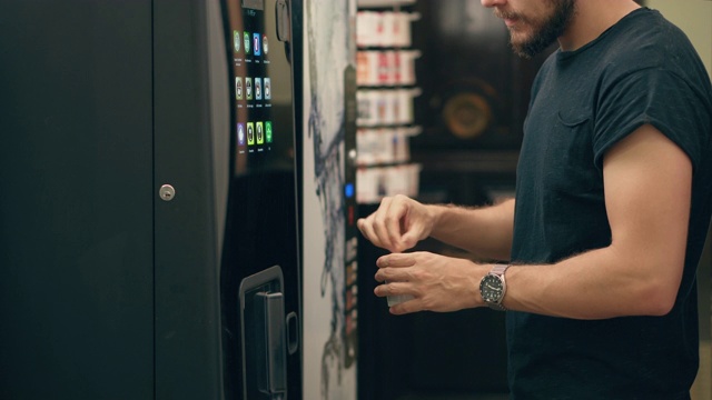 年轻人在自动贩卖机里搅拌咖啡视频下载