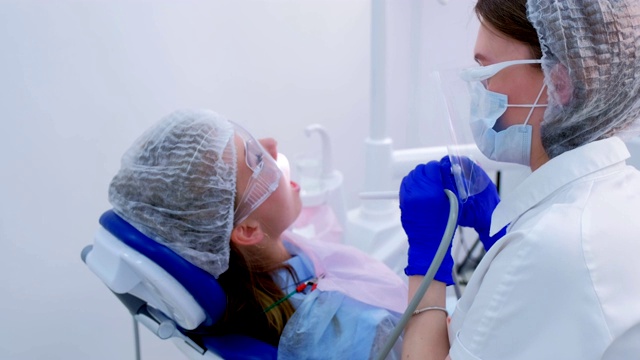 牙科保健师在口腔医学中做超声波清洁牙齿的妇女。视频素材