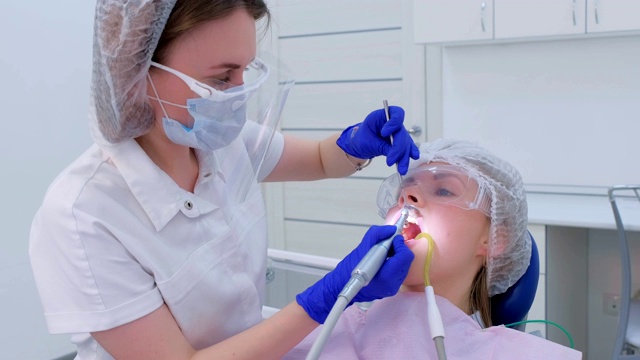 牙科医生用牙钻为妇女清洁、刷牙和抛光牙齿。视频素材
