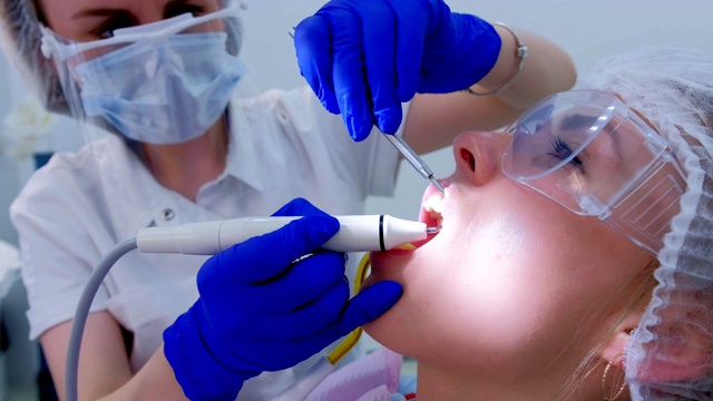 女病人在牙科用超声波清洗牙齿，近景。视频素材