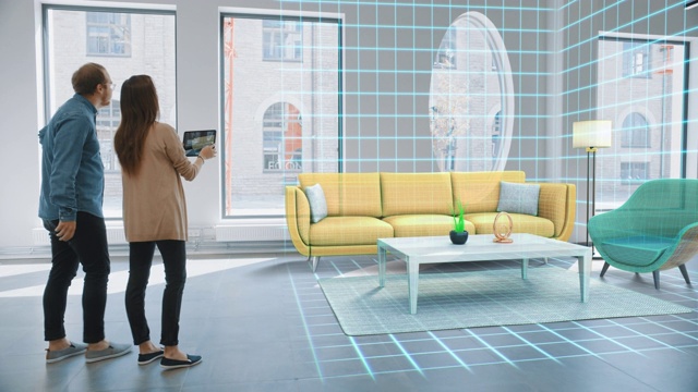装饰公寓:可爱的年轻夫妇使用数字平板电脑和增强现实室内设计软件为他们的家选择3D家具。人们选择客厅的沙发，桌子和照明视频下载