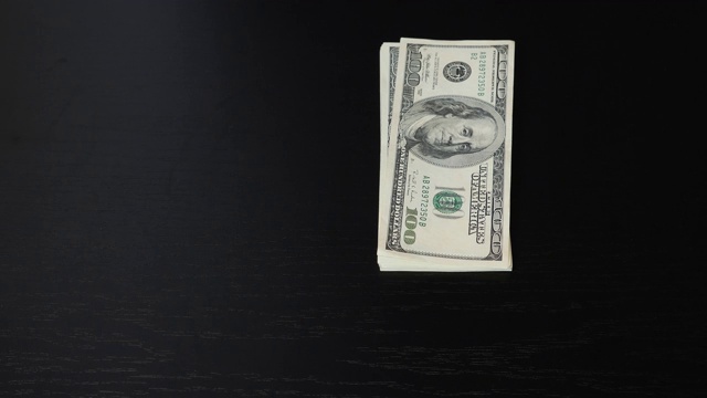 男人的手扔了一堆美元钞票在桌子上。近距离观察办公室桌上的一百美元钞票。成功的经营理念。金融和货币支付概念视频素材