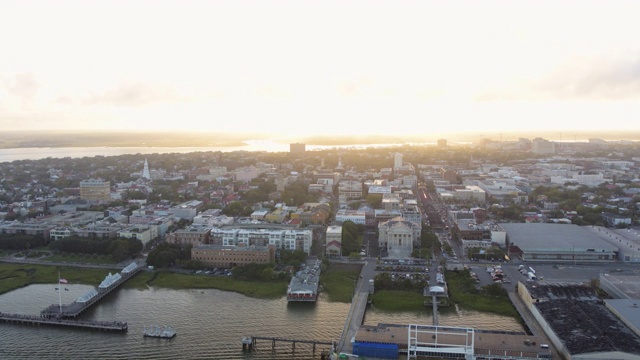 南卡罗来纳查尔斯顿航拍v128从低到高向后飞行，环绕法国区和港口，日落时可以看到城市景色视频素材