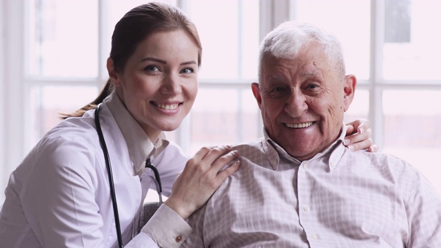 快乐健康的老年病人和女医生看着镜头视频下载