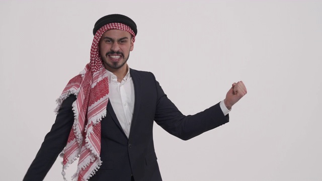 一个愉快的英俊的阿拉伯男子的特写表达积极的手势模仿吉他演奏。成功的情感。肢体语言的概念视频素材