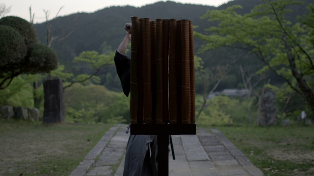 一位剑术精湛的剑术师将竹子切成薄片视频素材