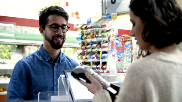 微笑的男人在商店用信用卡付款视频下载