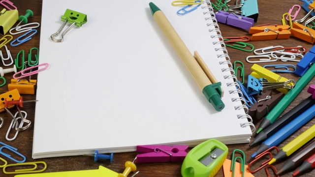 学校用纸笔记本和各种文具放在棕色的木桌上视频下载