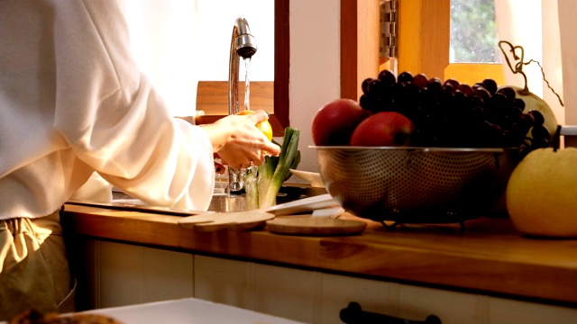 靠近女人的手在厨房洗水果透过窗户的光视频素材