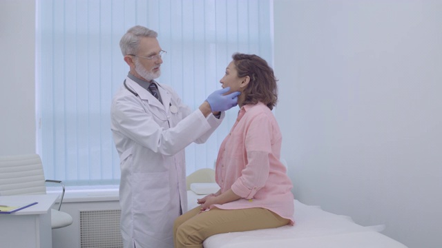 耳鼻喉科医生戴着手套检查患者颈部、疾病症状、感染情况视频素材