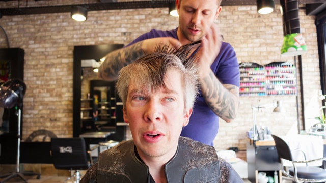 一个男人在时髦的理发店里剪头发的时间视频下载