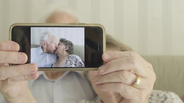 一对老年夫妇拿着智能手机对着摄像头视频下载