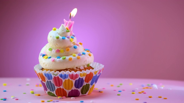 吹灭用糖屑装饰的生日蛋糕蜡烛视频素材