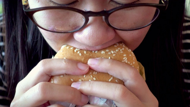 吃汉堡包的亚洲女人。视频素材