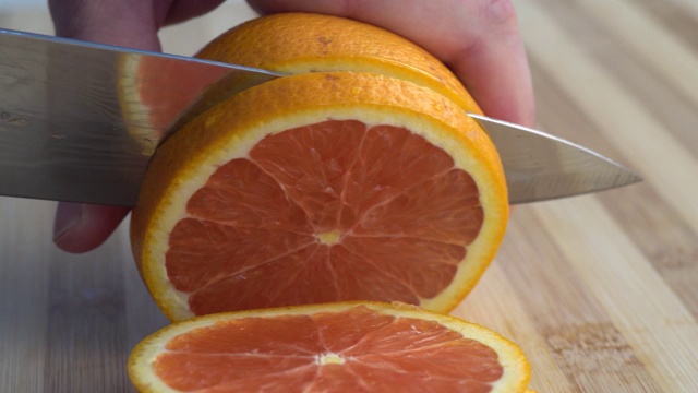 刀子切多汁的橘子。视频素材