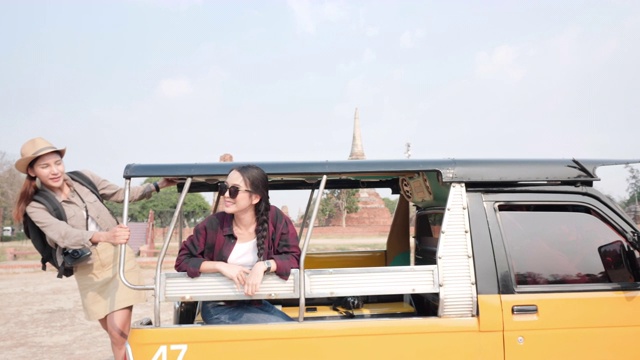 亚洲年轻女性和朋友兴奋地在世界遗产城市大城城享受汽车嘟嘟车。概念自由女人寻欢作乐，度假旅游旧城。慢动作视频下载