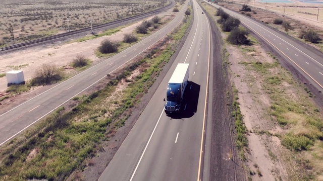 无人机拍摄的一辆长途半挂卡车在四车道公路上超速行驶视频下载