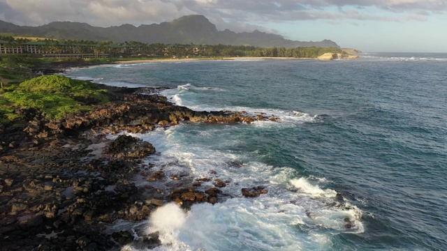 缓慢的飞越夏威夷海岸线与绿色的山脉在远处视频下载