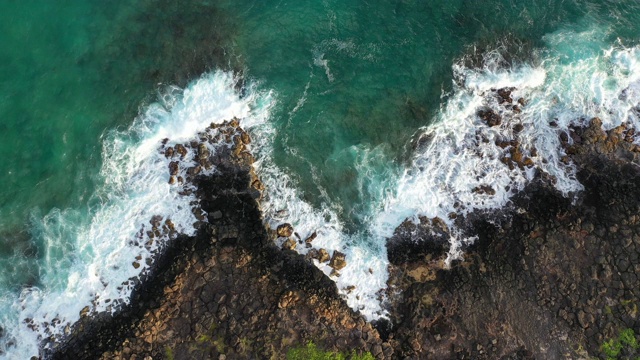 夏威夷火山岩石上蓝色海浪的鸟瞰图视频下载