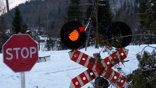 冬天森林里的铁路十字路口红灯闪烁。火车经过视频下载