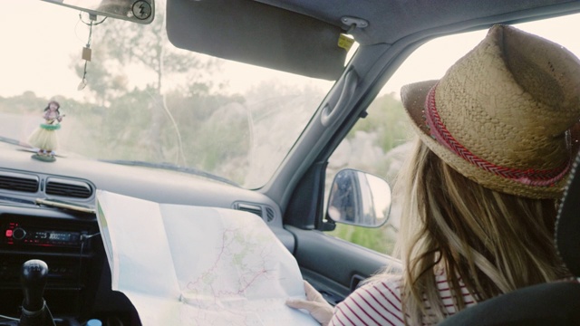 女人一边在车里说话一边拿着地图视频下载