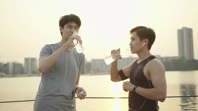 快乐的男人和朋友一起在户外运动的时候喝水和休息视频素材