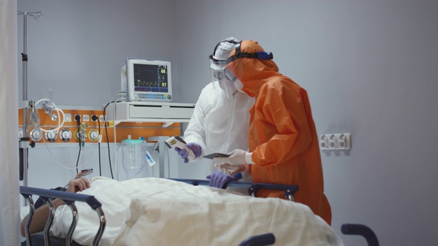 慢镜头:护士测量冠状病毒患者的体温，并咨询领先医生-宽摄影。拍摄于5K R3D视频素材