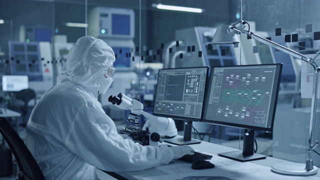 研究工厂洁净室:工程师和科学家团队在电脑上工作，使用显微镜检查主板微处理器，为医疗电子开发电子视频素材