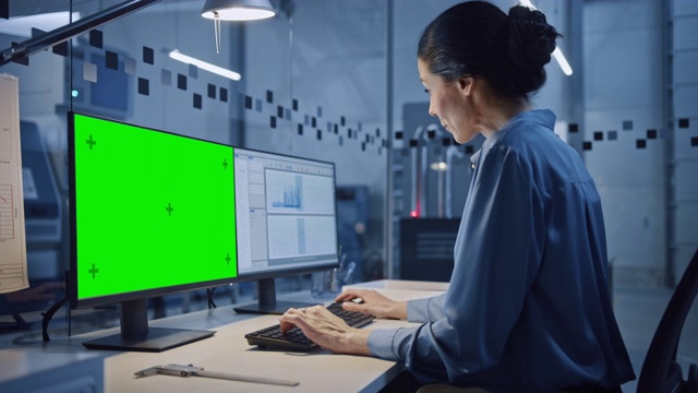工厂办公室:美丽而自信的女工业工程师在电脑上工作的肖像，绿屏色度键显示。配备数控机床的高科技设备视频素材