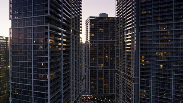 黄昏时分，正在上升的无人机拍下了迈阿密公寓大楼里的一模一样的塔楼视频素材