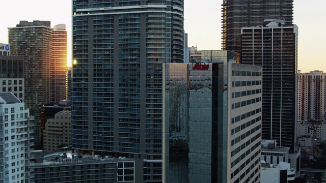 落日在布里克尔的办公楼和公寓大厦之间，迈阿密在日落-无人机拍摄视频下载