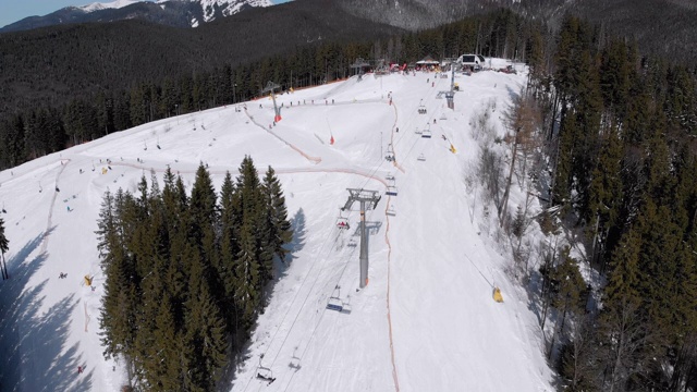 滑雪胜地的空中滑雪场与滑雪者和滑雪缆车。的雪山森林视频素材