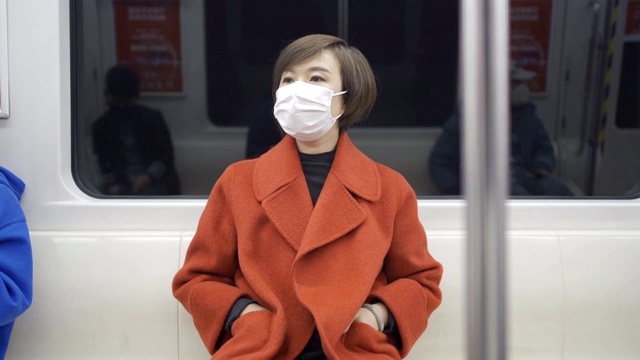 女性在地铁使用口罩保护自己免受COVID-19感染视频素材