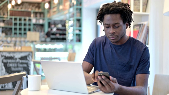 非洲人在咖啡馆使用智能手机和笔记本电脑视频素材
