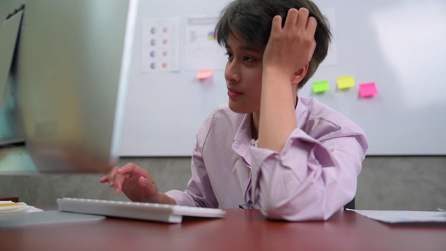 疲惫和无聊的年轻亚洲商务办公室女性工作在一个办公室的电脑视频素材