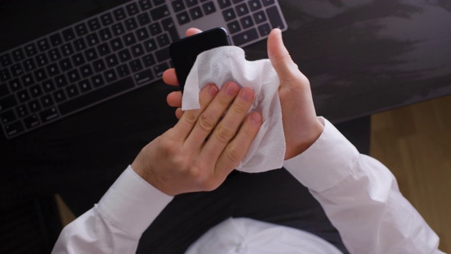 一男子用消毒湿纸巾擦拭智能手机视频下载