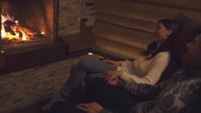 在壁炉边和男人聊天的女人视频素材