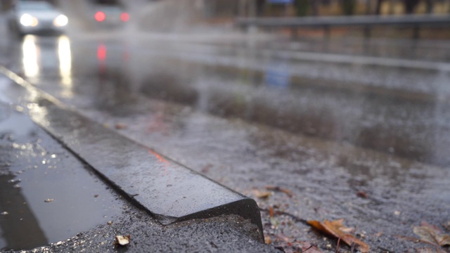 在秋天的雨天，在潮湿的道路上模糊的城市交通。视频下载