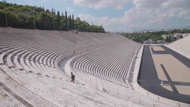 一位妇女在希腊雅典的泛雅典体育馆观光。视频下载