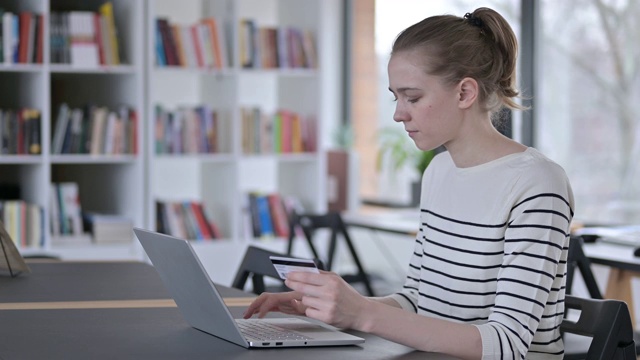 图书馆的年轻女子在手提电脑上成功付款视频素材