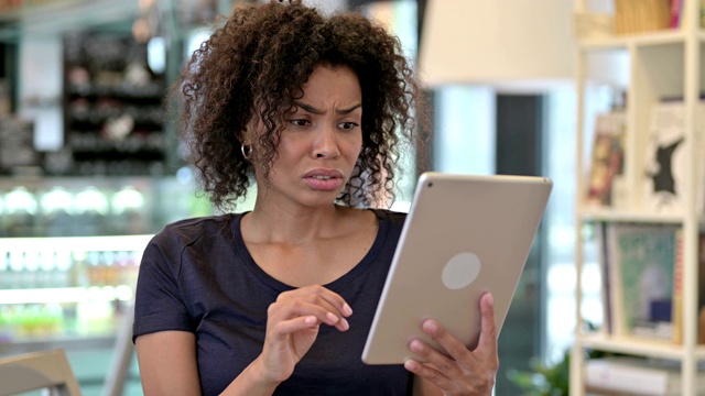 年轻的非洲妇女在平板电脑上对失去的反应视频素材