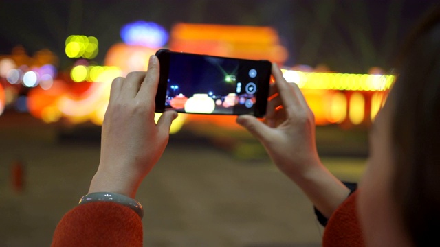 中国春节期间，女人用智能手机与城市景观视频素材