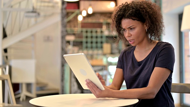 失败，年轻的非洲女人在咖啡馆的平板电脑上的失落视频素材