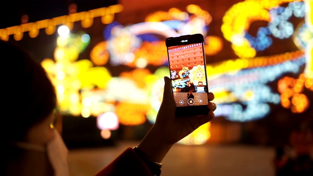 中国春节期间，女人用智能手机与城市景观视频购买