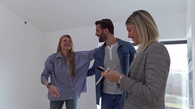 房地产经纪人祝贺一对年轻夫妇买了新房。视频下载